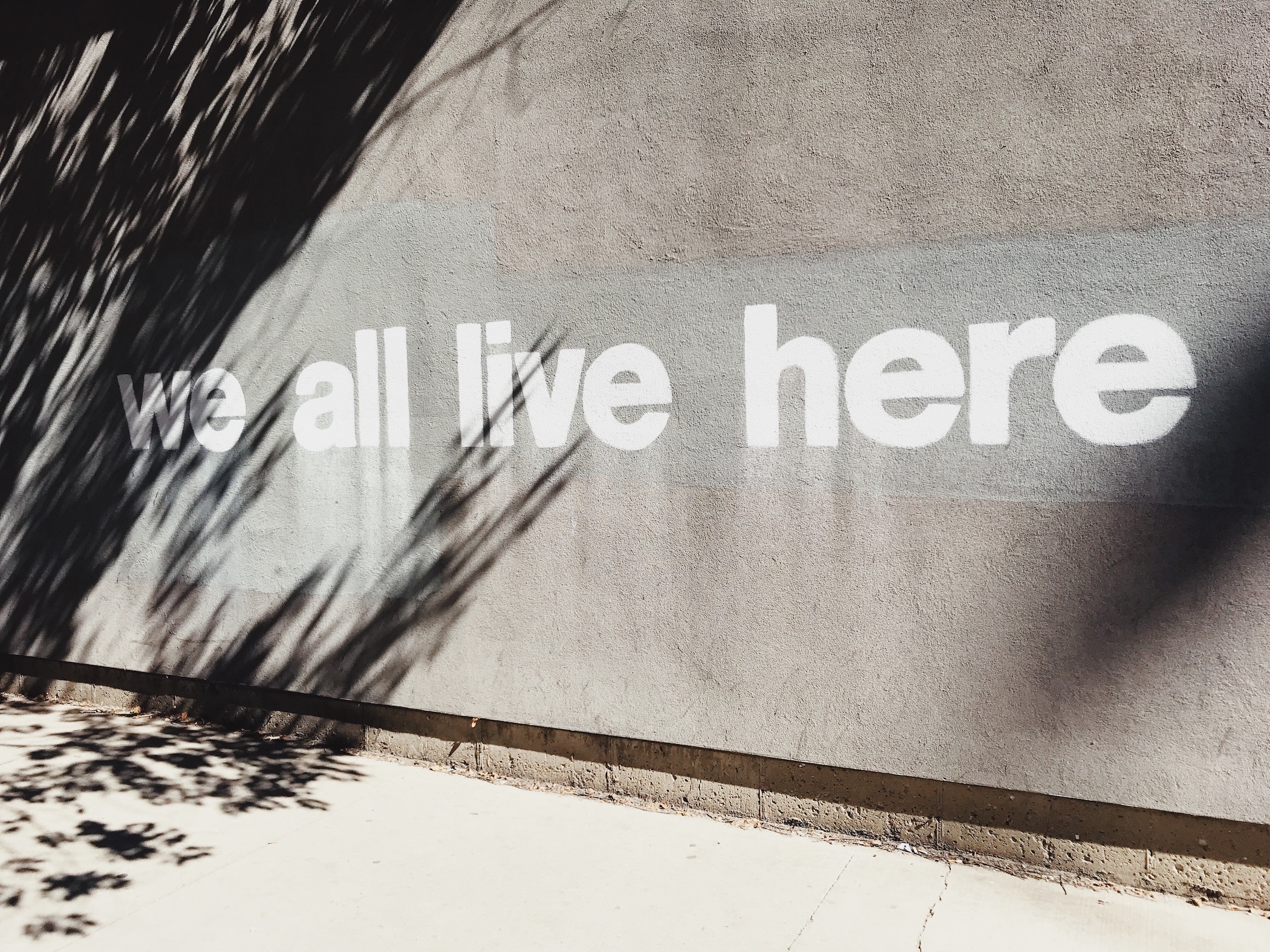 Wall that says 'we all live here'