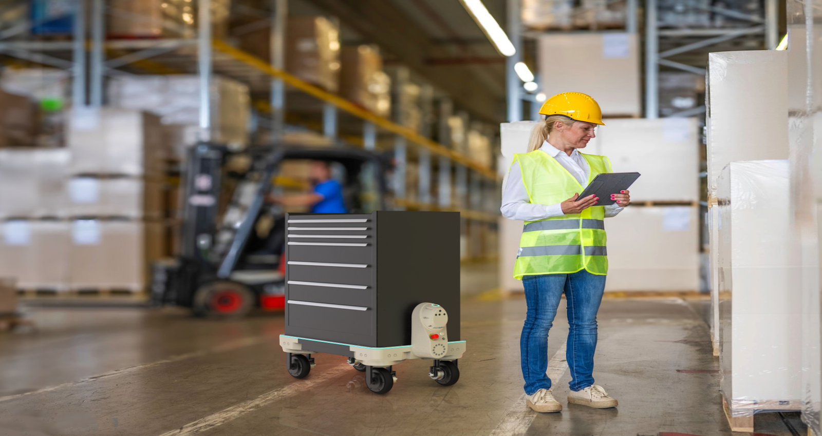 Warehouse worker in hardhat and yellow vest uses Kilo robotic flatbed 