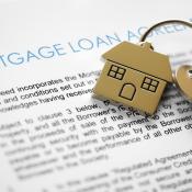 Paper with the heading "Mortgage Loan Agreement" with a house key laying on top of it