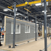 Assembling building panels in an off-site construction plant