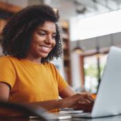 A woman applies for a scholarship on her laptop