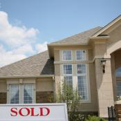 A house with a "sold" sign in the yard