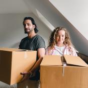 Happy couple unpacking boxes in new home