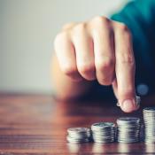 A man points to a stack of coins.