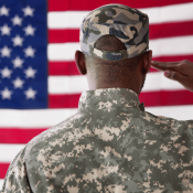 Member of U.S. military salutes American flag