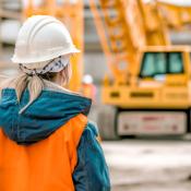 Woman in white construction hard hat and orange vest