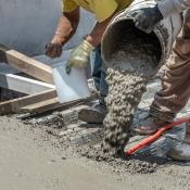 Builders pouring concrete on jobsite