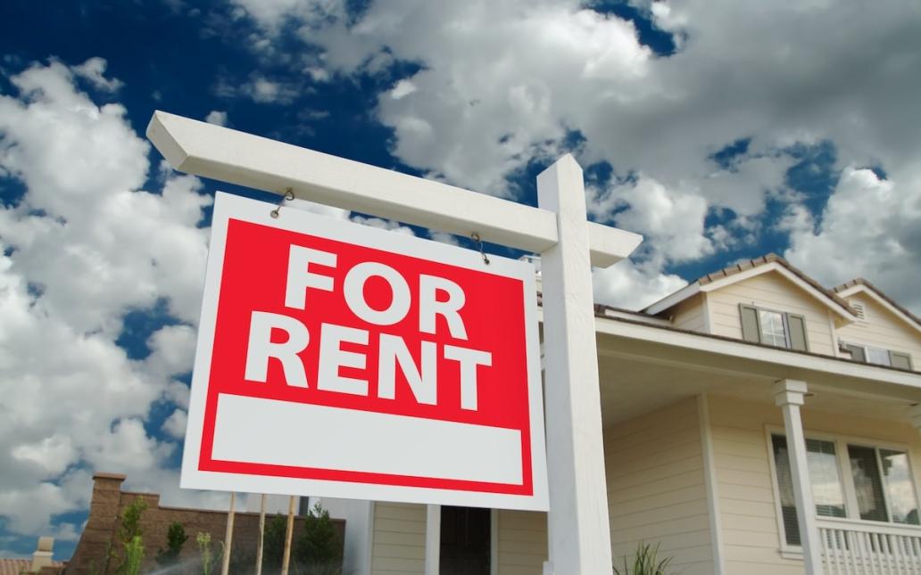 Red "For Rent" sign sits outside of single-family home