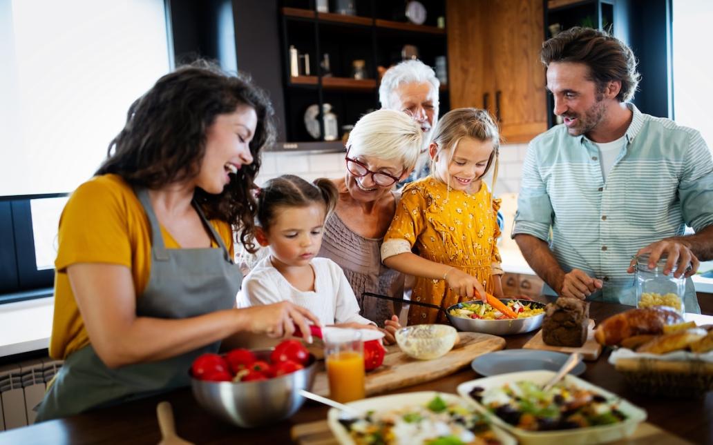 A family cooks together at a kitchen island