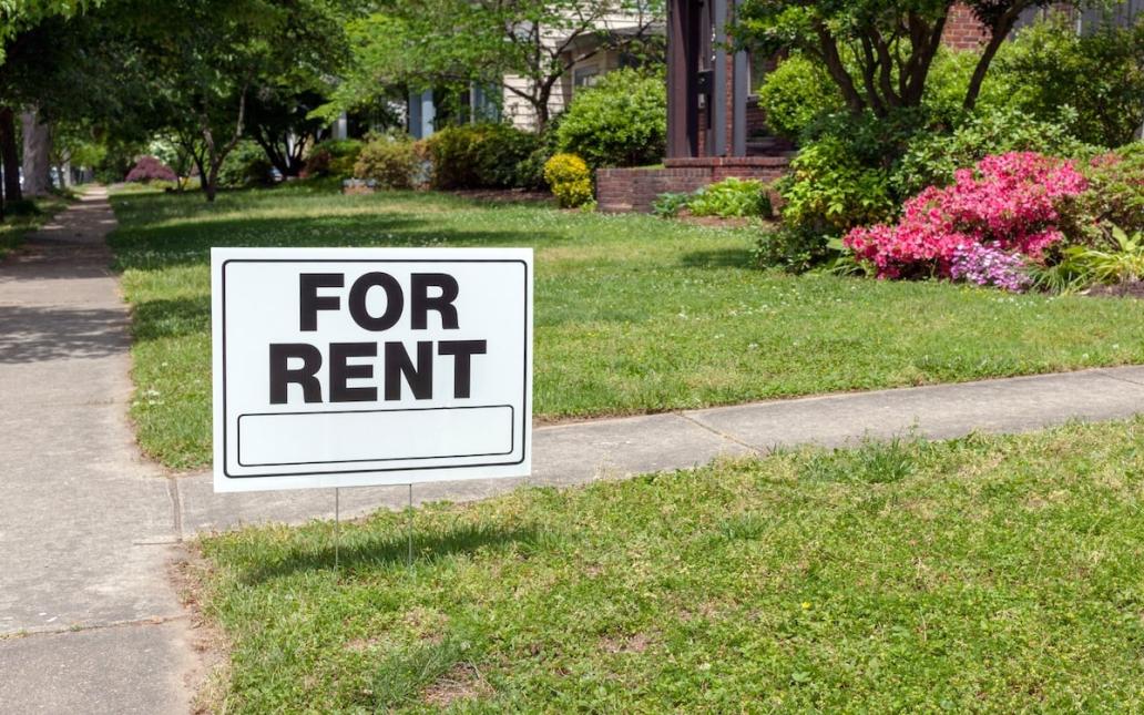 A "For Rent" sign posted in a front yard 