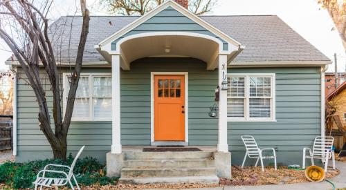 View of exterior of affordable starter home with an orange front door