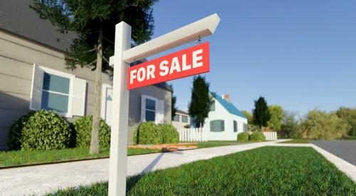 For-sale sign sits in front yard of single-family home