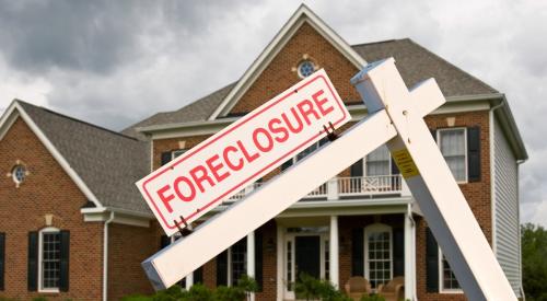 A foreclosure sign sits in front of suburban home