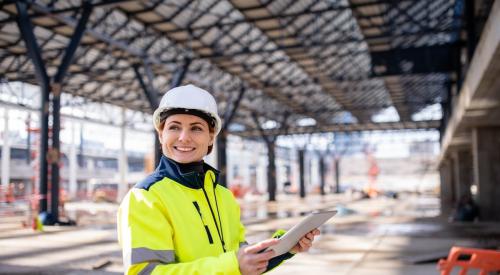 Female construction worker poses at jobsite