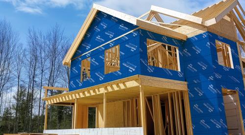 Energy-saving integrated continuous insulation, weather-resistive barrier and seam sealer installation on new wood frame home