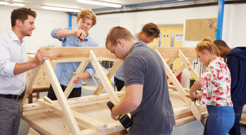 Students learning carpentry skills in a construction trades class
