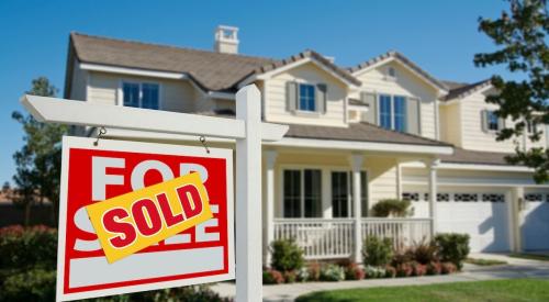 Sign reading "sold" sits on front lawn of home