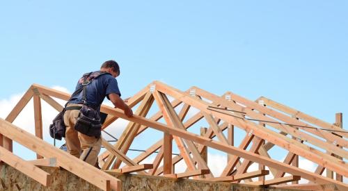 Residential builder works on roof of house