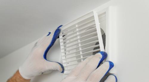 Worker installs ventilation grill