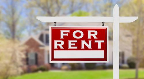 "For Rent" sign posted in a front yard of a single-family home