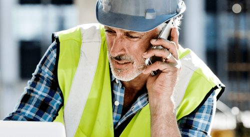 American Express image of construction worker on mobile device