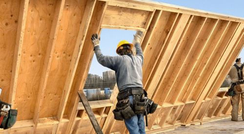 Builders putting up house frame, Photo: AMEX
