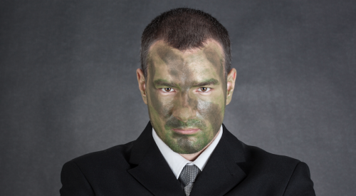 businessman wearing suit with face painted in camo for surviving battle