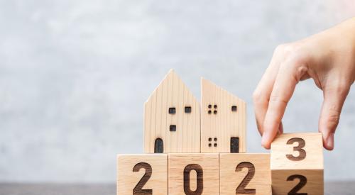 Calendar blocks flipping from 2022 to 2023 with small wooden houses in background