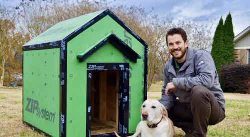 Homebuilder posing with dog in front of doghouse made from Zip tape
