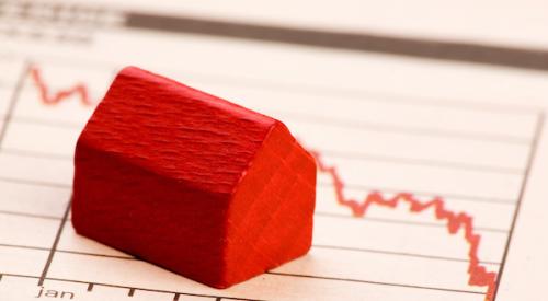 Red house figurine with chart showing home prices dropping