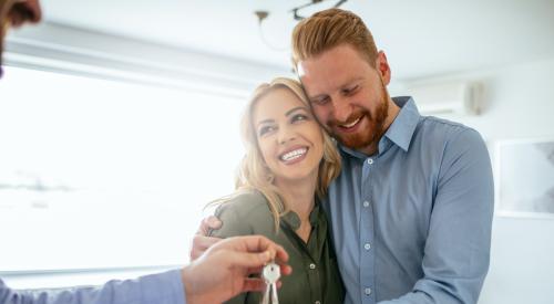 Smiling couple receiving house keys