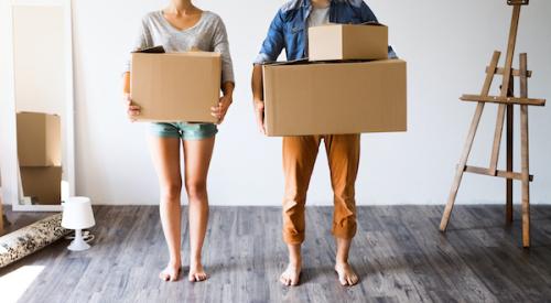 A couple holding moving boxes