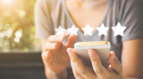 Woman using phone to leave 5 star rating