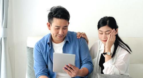 Couple looking upset as they realize they can't afford to buy a home