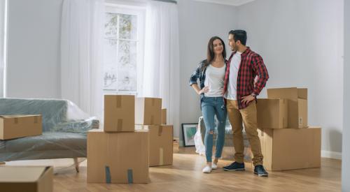 Smiling couple in room with moving boxes