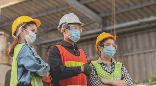 Group of three construction workers wearing masks