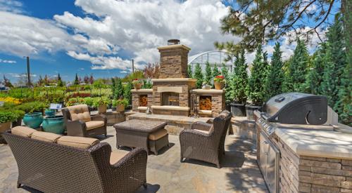 Outdoor space with kitchen, fireplace, and furniture 