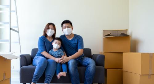 Family with masks and moving boxes