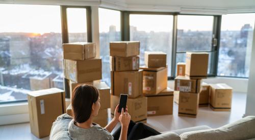 Woman sitting in city skyrise with moving boxes
