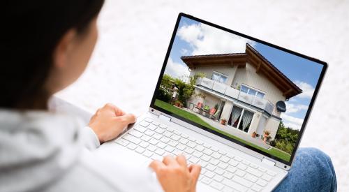 Person searching homes on laptop