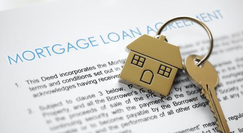 Mortgage application in background with home keys on top