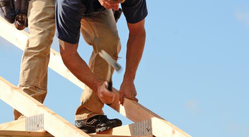 Worker hammering roof