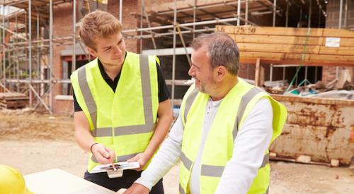 Home builder talking to apprentice