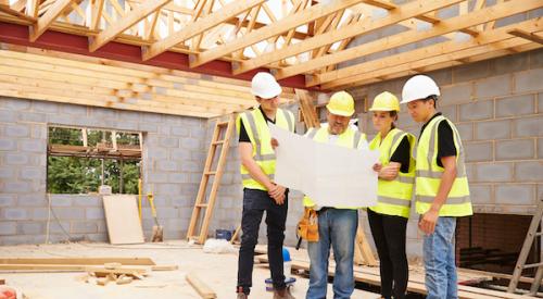 Group of home builders reviewing blueprints 