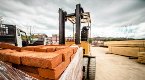 Bricks are carried through a construction site