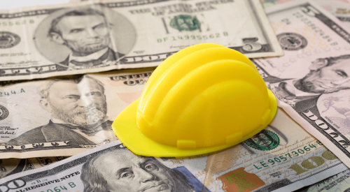 Construction spending with yellow hardhat on US currency