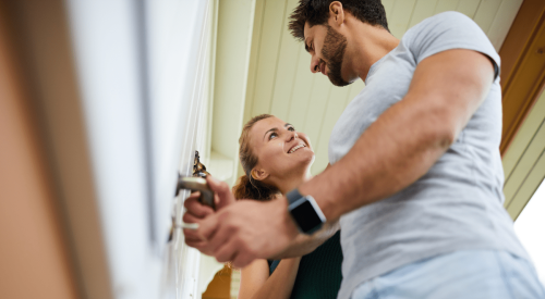 U.S. homeowner couple unlocking door of their new home
