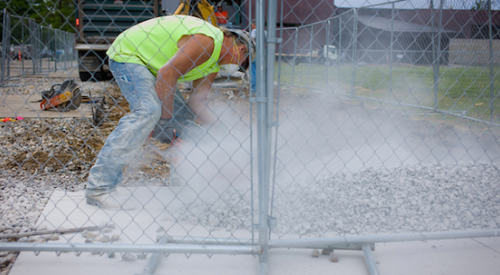 Construction worker cuts concrete kicking up a lot of silica dust.