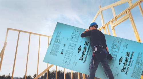 Man carrying sheathing panel for home walls