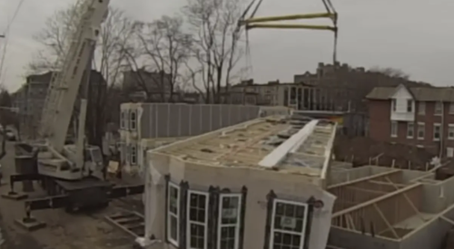 Crane lowering a modular unit on a construction site